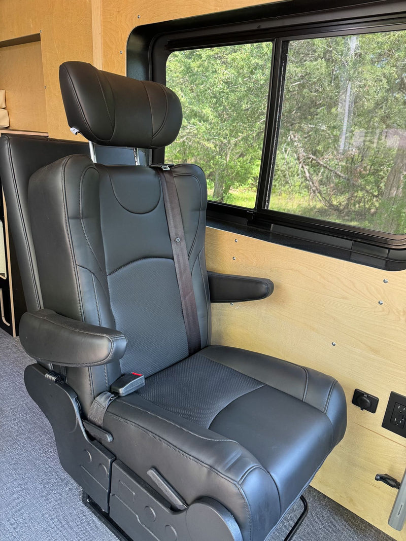  set against warm wood walls and a large window.|Spacious RV rental van interior: custom kitchen with sink — photo 16