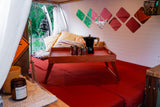 Comfortable RV rental interior showing a red bed, coffee tray, and decorative wall panels for a cozy stay.
