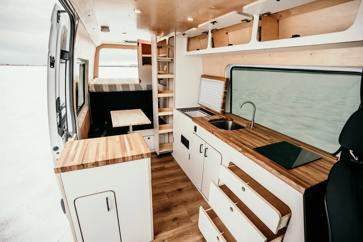  parked in snowy mountains with ski/snowboard gear on the ground.||||||||||||Inside an RV rental's rear cargo area — photo 3