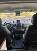 RV rental: Inside a clean camper van cockpit, showing the dashboard, driver's seat, and road view.