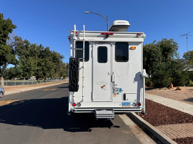  parked on a sunny residential street.|White truck camper — photo 5