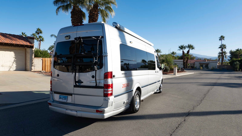 bright salt flat under a vast blue sky with light clouds.|A silver Airstream Interstate RV rental van — photo 2