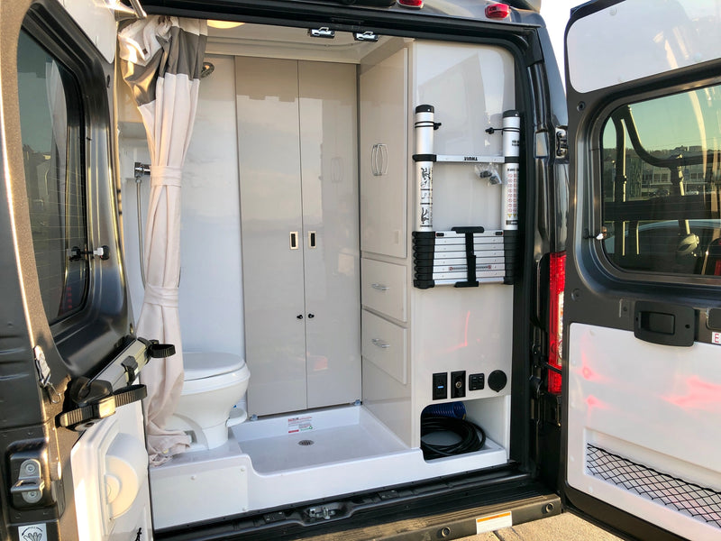 Inside an RV rental: compact bathroom with toilet/shower, built-in storage, and Thule ladder. — photo 5