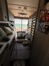 RV rental: Remote work setup in a camper van with a stunning ocean view, perfect for digital nomads from their mobile office.