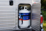A white propane tank is securely stored in a side compartment of an RV rental, essential for camping adventures.