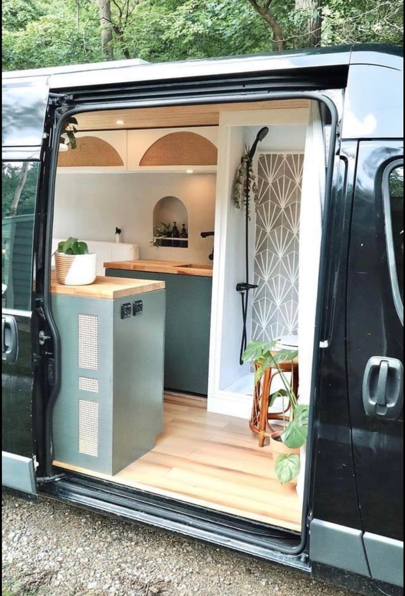 Stylish RV rental van conversion: a modern kitchen with green cabinets & a sleek shower with geometric walls. — photo 9