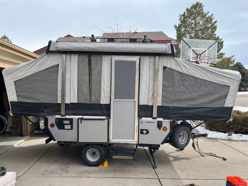 This pop-up camper, a versatile RV rental option, is shown fully set up in a driveway, perfect for camping & outdoor adventures. — photo 2