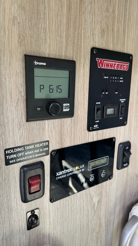 Inside an RV rental: Truma heater, Winnebago monitoring panel, Xantrex solar controller & holding tank heater.