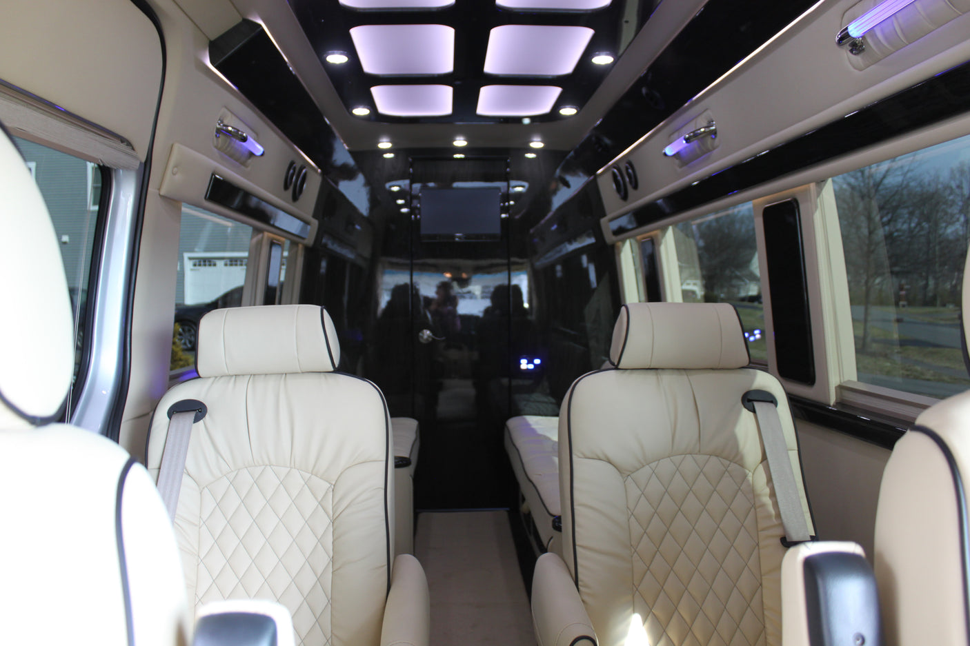Premium RV rental interior with cream leather seats, ambient lighting, and entertainment system for comfortable travel.