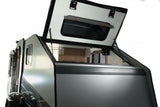 Adventure-ready pop-top RV rental. View of a sleek camper's open roof, revealing a compact interior for mobile living and travel.