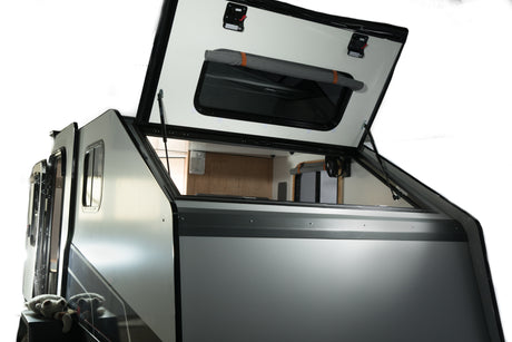 Adventure-ready pop-top RV rental. View of a sleek camper's open roof, revealing a compact interior for mobile living and travel.