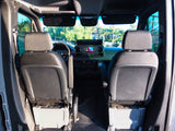 View inside an RV rental van, looking forward from the rear. Shows front seats and dashboard with a large infotainment screen.