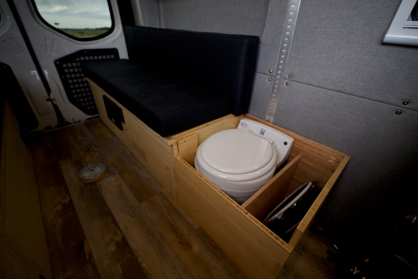  and custom wooden cabinets. View of open fields.|Inside this RV rental: a modern camper van interior with kitchen — photo 12