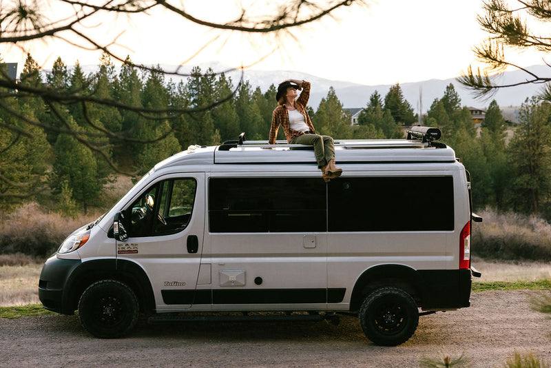  ready for adventure.|Woman on a camper van roof enjoying mountain views. Explore nature with an RV rental for your next adventure.|This Pleasure-Way Tofino RV rental floor plan shows an adaptable interior with a queen bed — photo 3