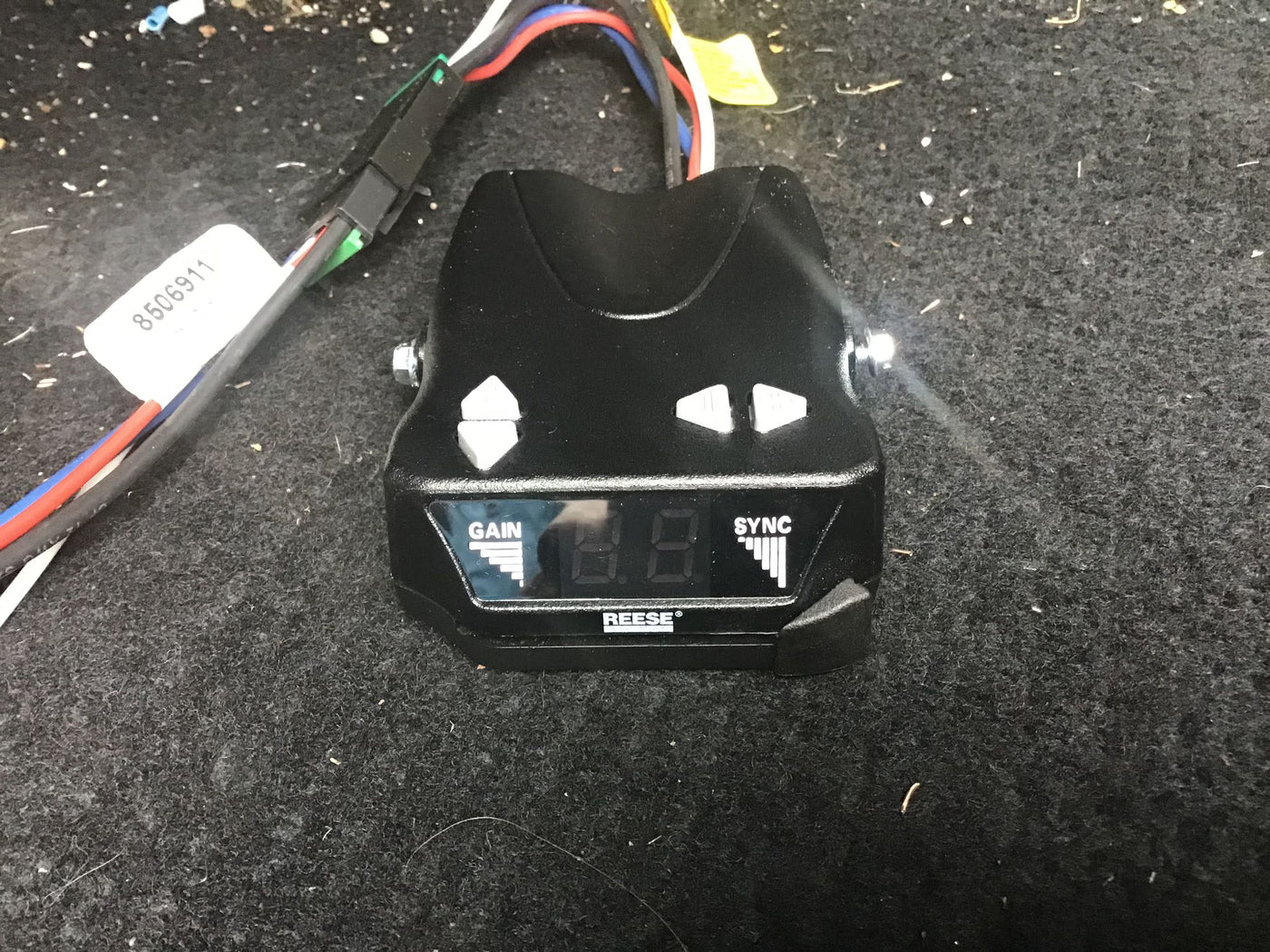 Black Reese trailer brake controller for RV rental, with 'GAIN' and 'SYNC' labels, on dark carpet. — photo 18