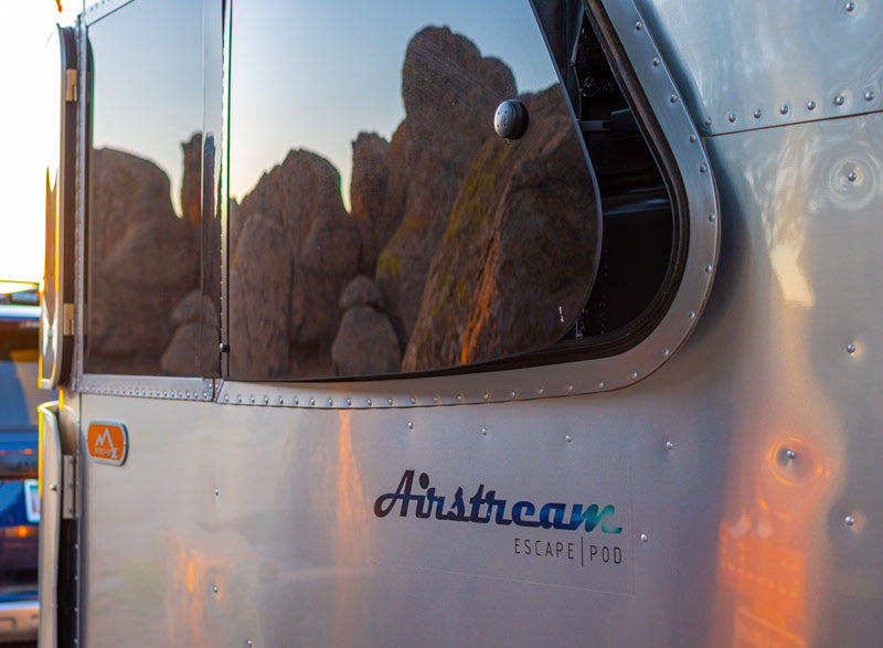 Airstream Escape Pod RV rental parked, reflecting rocky landscape in its shiny exterior. — photo 4