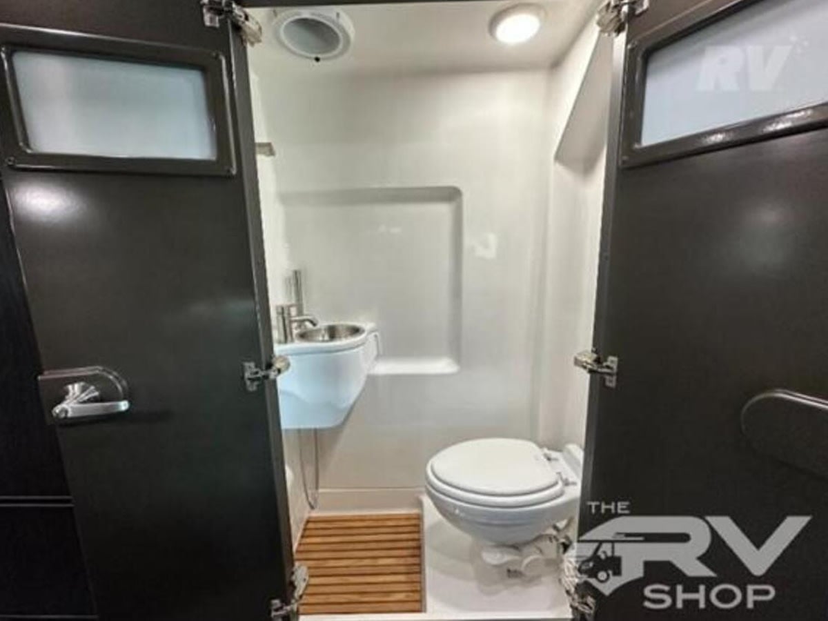  and sleek overhead storage.|Spacious RV rental interior featuring a modern kitchen with microwave & fridge — photo 17