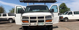 Front view of a white Chevrolet Express van, an RV rental, with doors open. Other vehicles are parked in the lot.