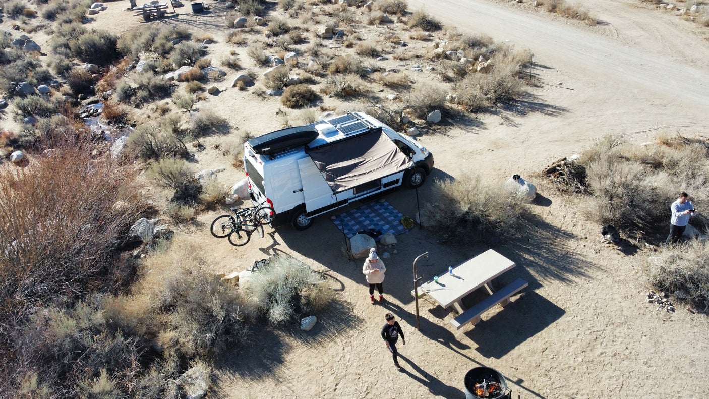 Enjoying a remote desert camp with an RV rental, complete with solar power, bikes, and a picnic area by a creek.