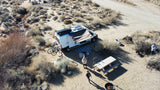 Enjoying a remote desert camp with an RV rental, complete with solar power, bikes, and a picnic area by a creek.