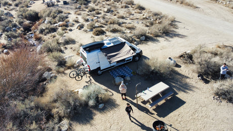 Enjoying a remote desert camp with an RV rental, complete with solar power, bikes, and a picnic area by a creek.