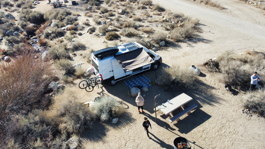 Enjoying a remote desert camp with an RV rental, complete with solar power, bikes, and a picnic area by a creek.