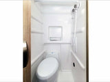 This compact RV rental wet bath features a toilet and an integrated shower with a handheld showerhead, all in white.