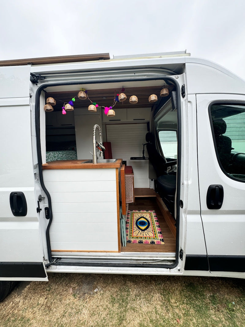  photographing Joshua Tree desert scenery with visible moon.|Step inside this cozy RV rental! Features a full kitchen — photo 4