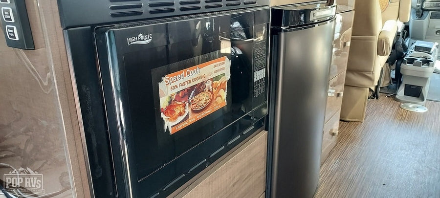 This RV rental features a High Pointe Speed Cook microwave and a compact refrigerator, perfect for efficient cooking and storage on your travels.