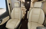 Elegant RV rental interior: cream leather seats with diamond stitching and dark piping offer luxurious comfort for travel.