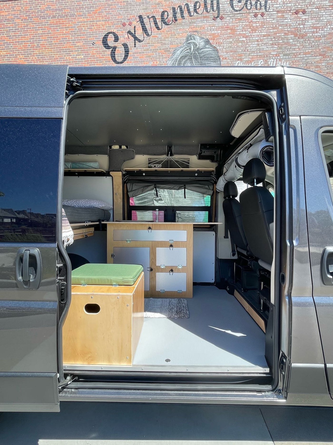  parked by vibrant Chuck E. Weiss wall mural.|Camper van RV rental: A dark gray Ram ProMaster with its side door open — photo 3