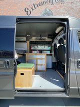 Step inside this RV rental! A custom camper van interior featuring a kitchen, bed, and seating area. Ready for adventure.