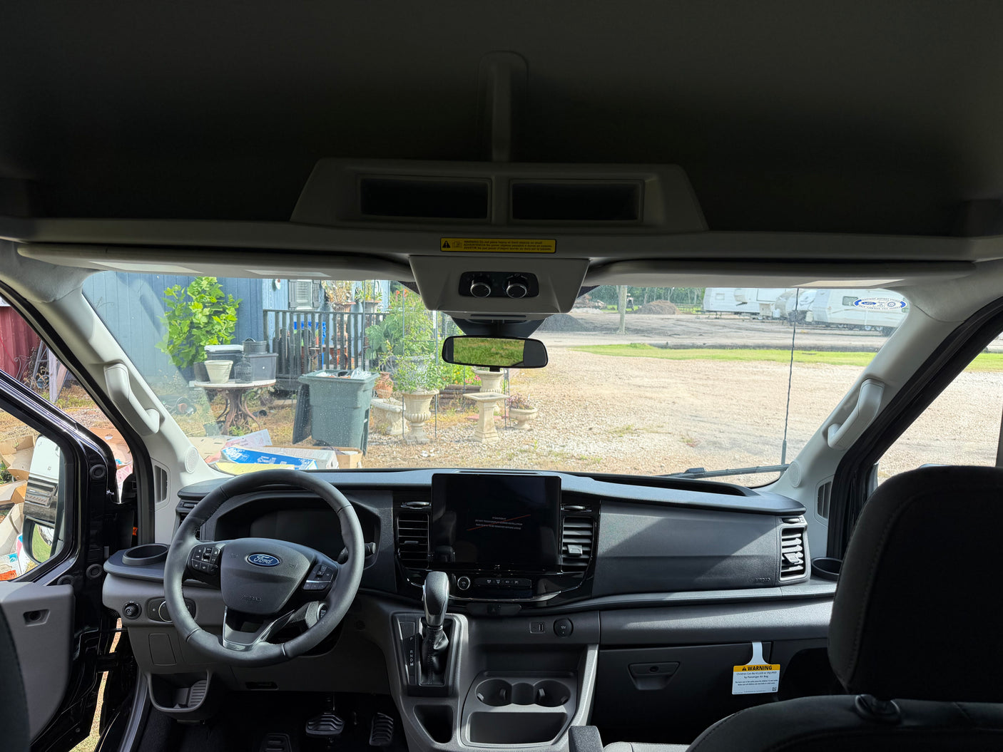 RV rental ready: interior view of a modern Ford Transit van, showing the dashboard, steering wheel, and infotainment screen.