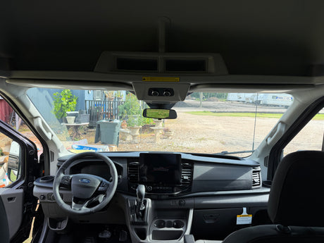 RV rental ready: interior view of a modern Ford Transit van, showing the dashboard, steering wheel, and infotainment screen.