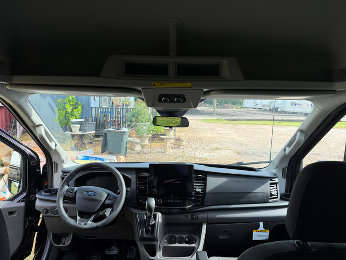 RV rental ready: interior view of a modern Ford Transit van, showing the dashboard, steering wheel, and infotainment screen.