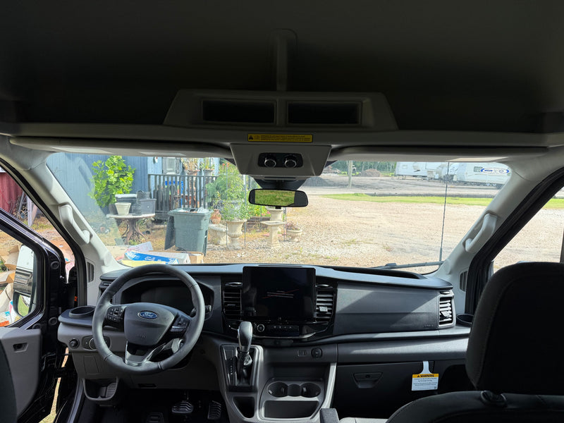  parked on grass. Reflective surface shows sky & trees. Texas plate XXL-0132.|Black Ford Transit van — photo 3
