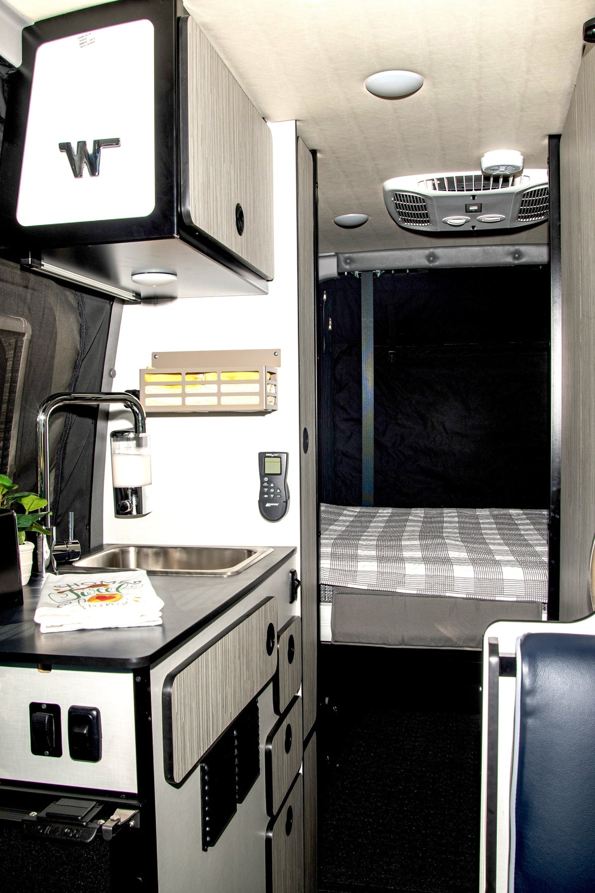 Inside an RV rental: modern camper van interior with a well-equipped kitchenette