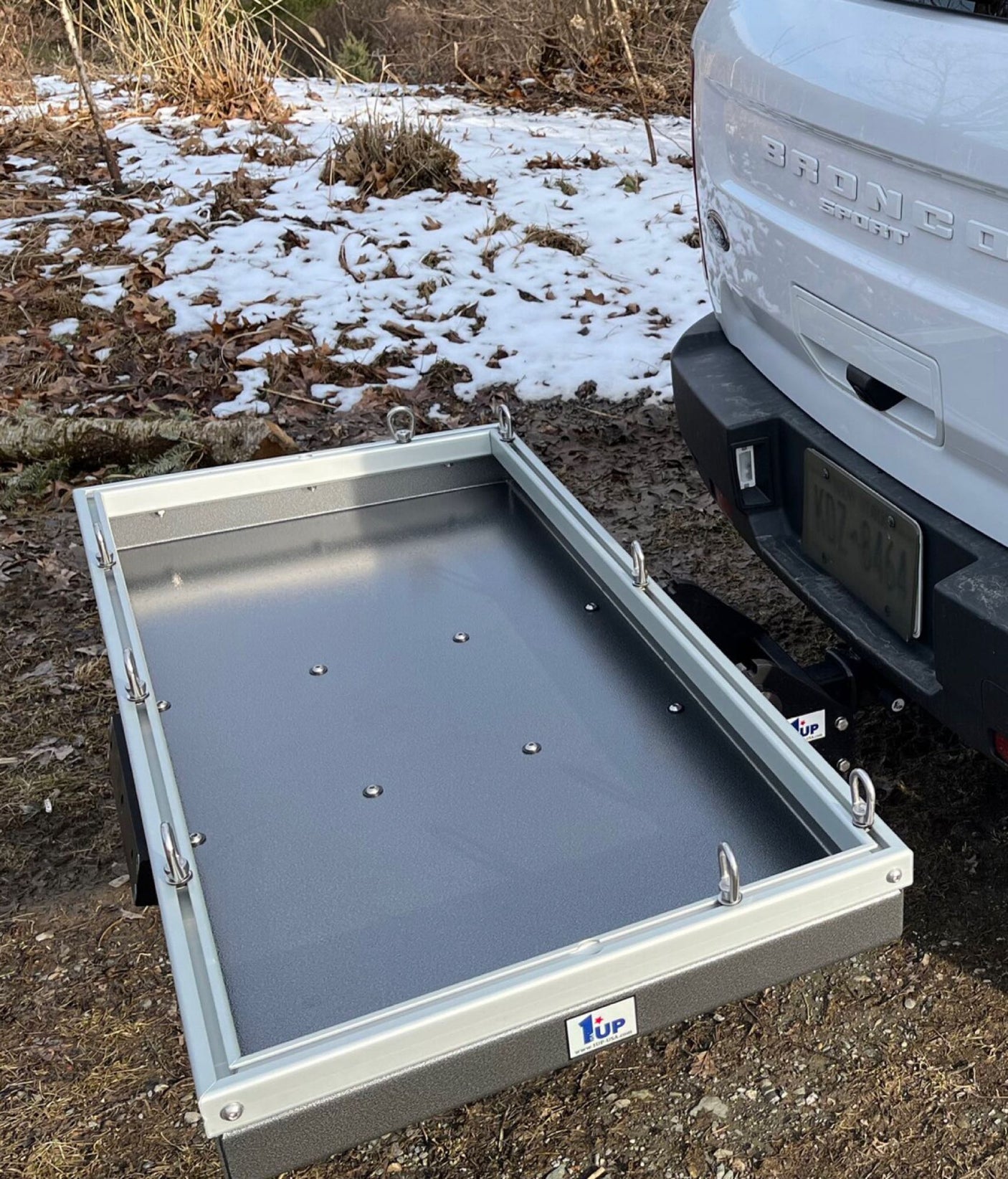 A sturdy hitch cargo carrier attached to a white Bronco Sport, providing extra gear space for RV rental adventures.