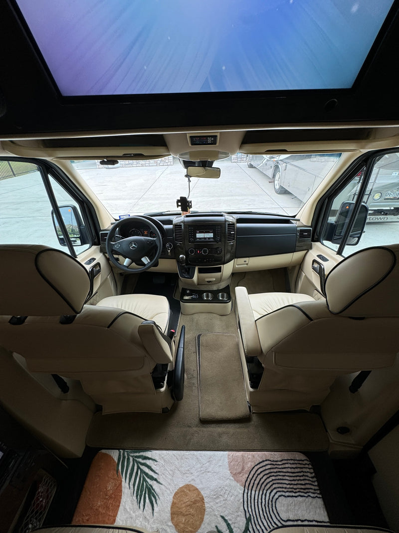 Step inside this RV rental: a spacious cockpit with beige interior, panoramic roof, and comfortable front seats. — photo 14