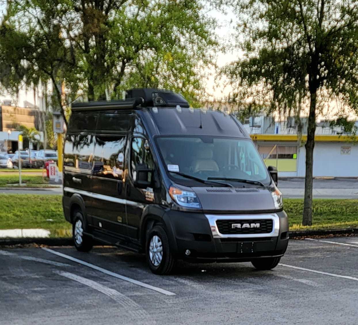Dark grey Ram ProMaster RV rental van parked in a lot, equipped for travel. — photo 12