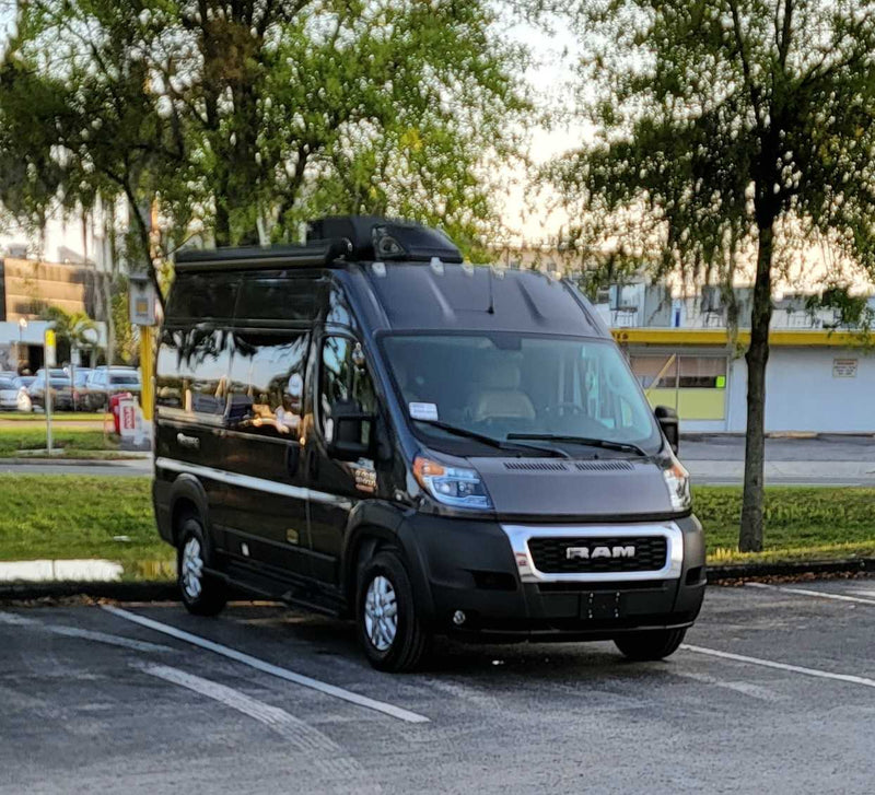 Dark grey Ram ProMaster RV rental van parked in a lot, equipped for travel. — photo 12