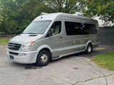 Silver Airstream Sprinter camper van RV rental, showcasing its amenities, parked on a paved driveway.