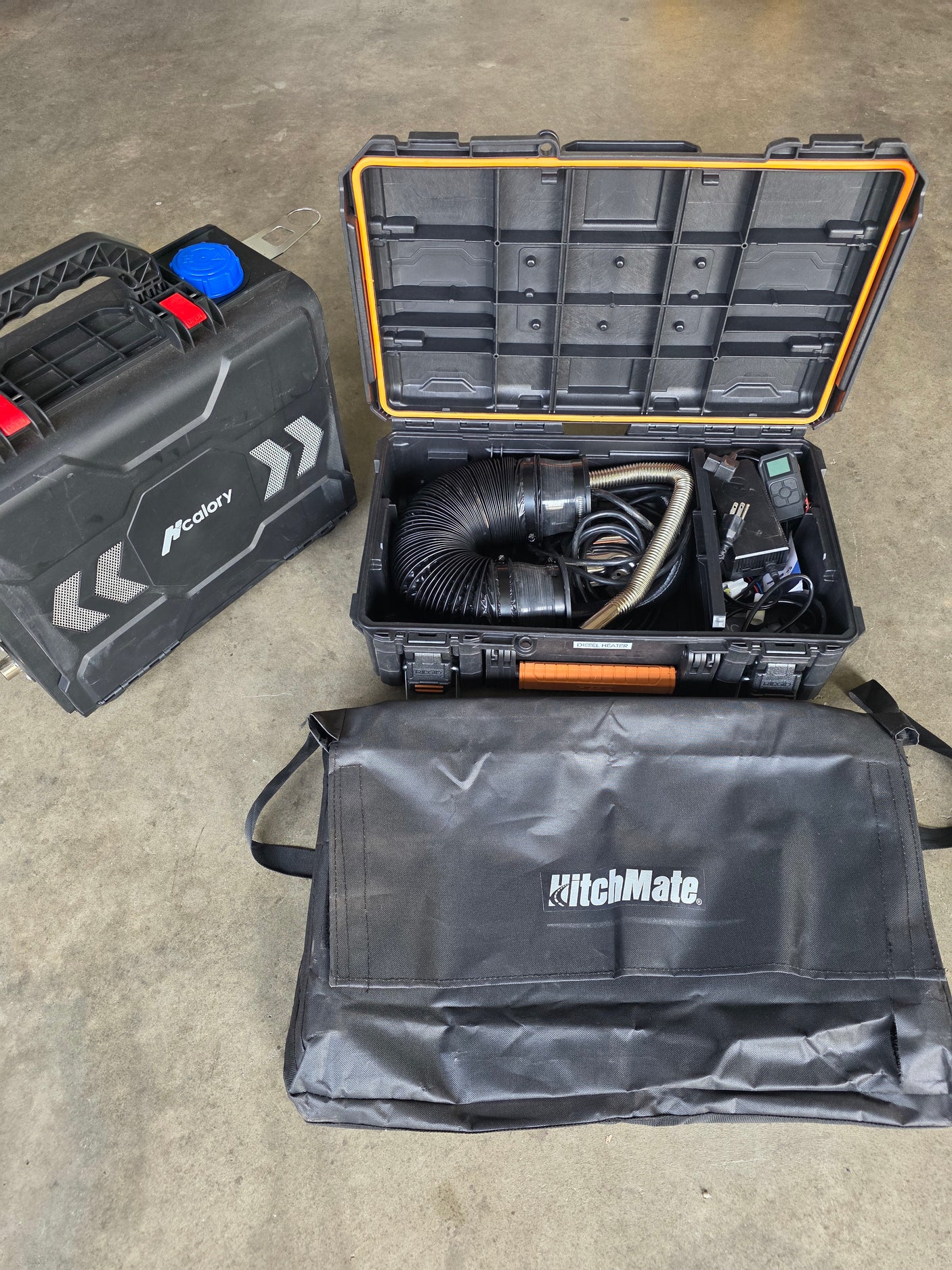 Portable MCalory diesel heater system in black cases for RV rental adventures, with a HitchMate bag.