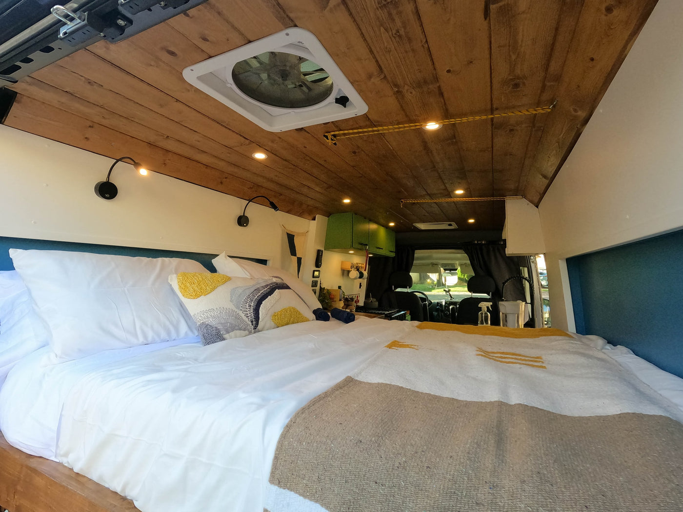 Plush bed, wooden ceiling, and bright lighting in this modern RV rental interior. Explore comfort on wheels for your next trip! — photo 15