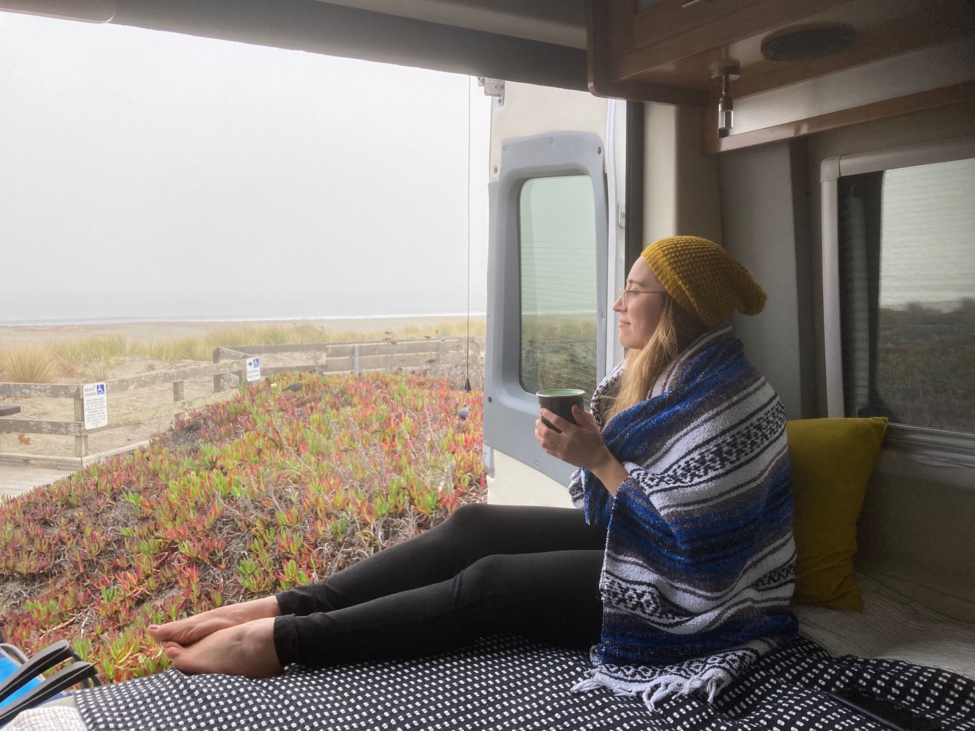  and two camping chairs set up outside. Perfect for road trip adventure!|Modern kitchenette in a compact rv rental. Features a stove — photo 9