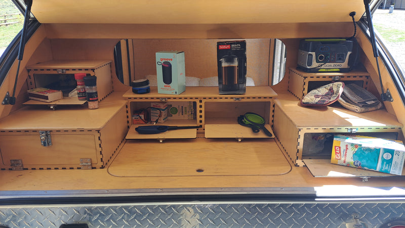 RV rental teardrop kitchenette, neatly organized with a Goal Zero power station, French press, speaker, and essential camping gear. — photo 13