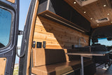 Cozy RV rental interior with wood paneling, kitchenette, and dinette, perfect for mobile adventures.