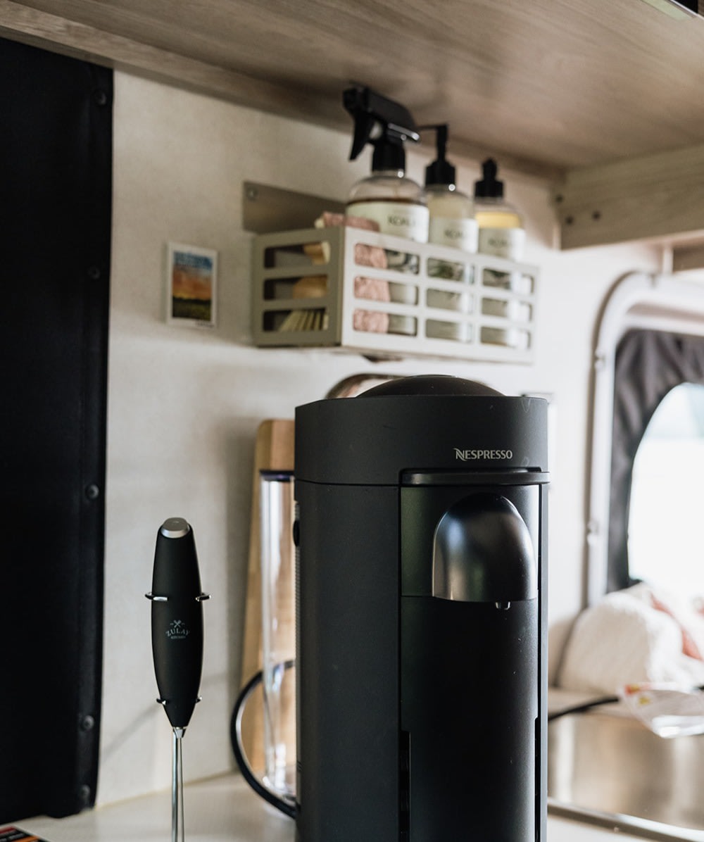  & sink for easy meal prep on the go.|Inside an RV rental: a wall caddy holds Koala Eco products above a sink with a cutting board — photo 4