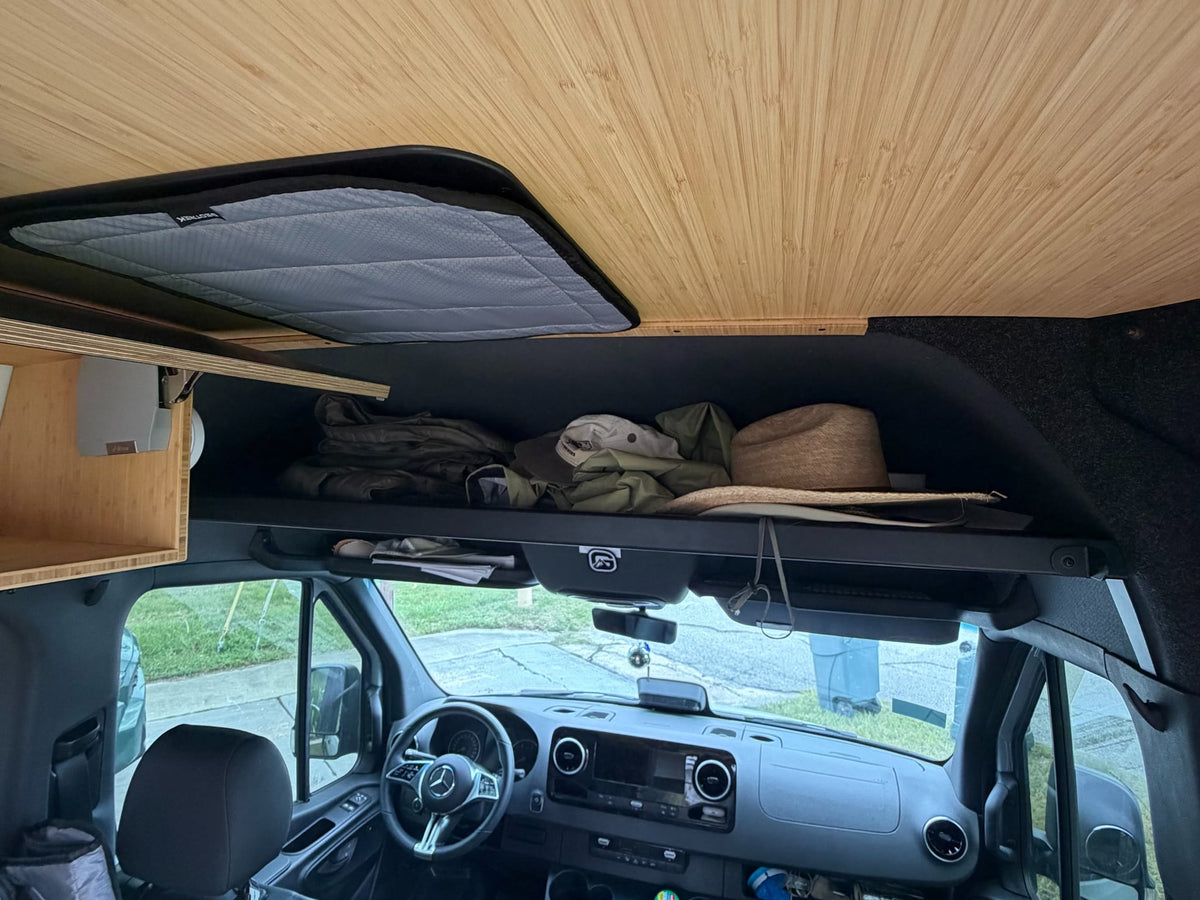  showing an open pop-out window & rear ladder. Ready for your next adventure.|RV rental camper van features an outdoor shower. Handheld showerhead and fixture on the wooden interior with open doors.|Open RV rental door reveals custom interior insulation and storage panels — photo 16