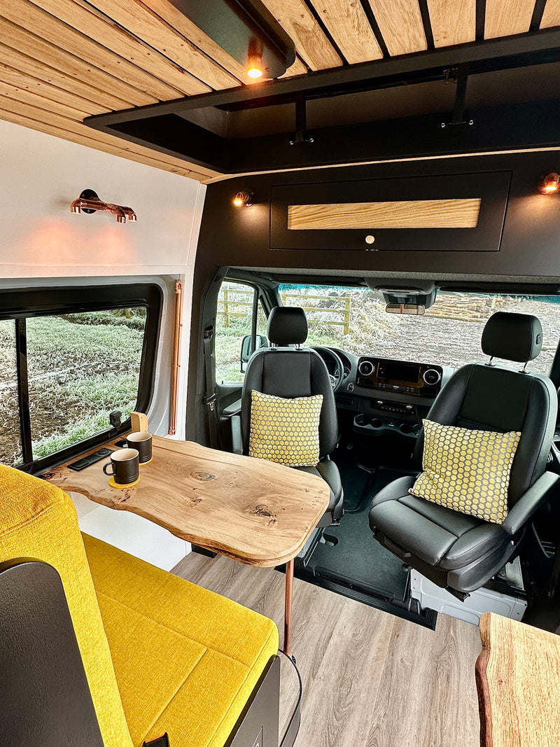 Spacious RV rental interior featuring vibrant yellow seating, live-edge wood table, and a sleek driver's cabin. — photo 3